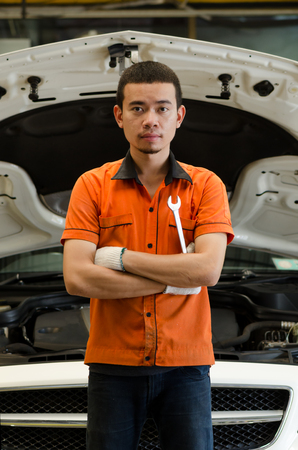 Mechanic With Wrench In Front Of Car In Car Service Shopの写真素材