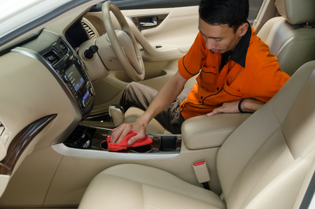 Hand with red microfiber cloth cleaning interior car.の写真素材