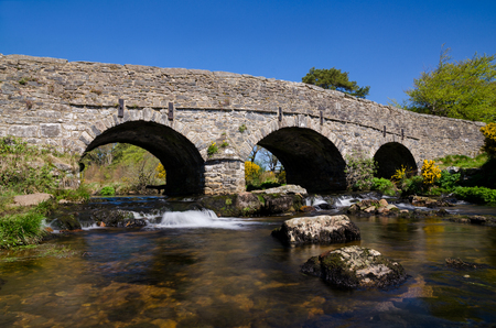 The Ancient Stone Bridge Over Dart River At Postbridge within Dartmoor National Park, Devon, England