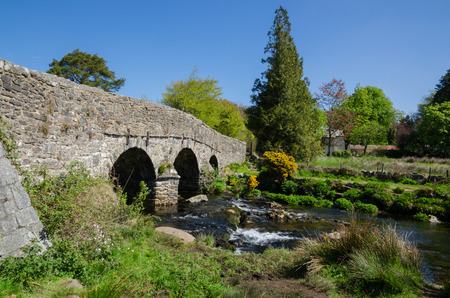 The Ancient Stone Bridge Over Dart River At Postbridge within Dartmoor National Park, Devon, Englandの写真素材