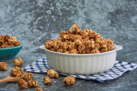 Sweet Caramel Flavoured Popcorn In Blow On Cement Tableの写真素材