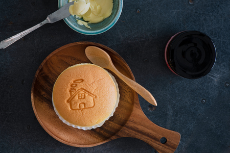 Top View Of Taiwanese Sponge Cake (Castella Cake) On Wood Plate  With Butter Cup And Jam Bottle On Grey Tableの写真素材
