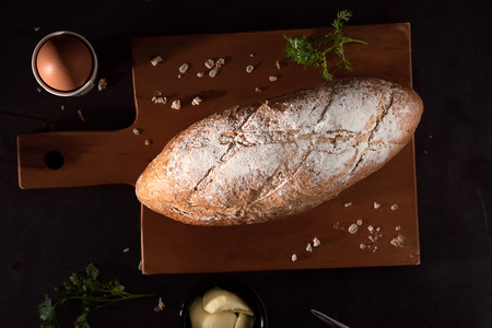 Pain de campagne  Or country bread in French On Wood Plate  And Steel Table With Cup Of Butter.