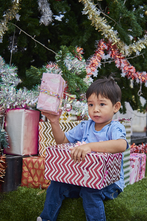 Asian Child Play With Decorated Christmas Tree And Present Boxesの写真素材