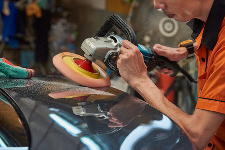 Hands Polishing Car With Rotary Car Polisher. Polishing On Car Paint Surface. Foam Pad In Blur Motion From Vibration Of Polisher Machine. Selected Focusの写真素材