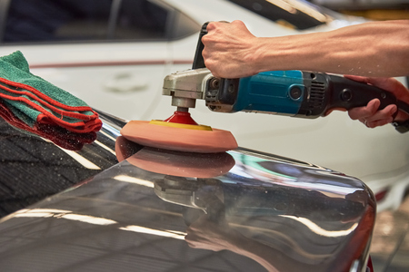 Hands Polishing Car With Rotary Car Polisher. Polishing On Car Paint Surface. Foam Pad In Blur Motion From Vibration Of Polisher Machine. Selected Focusの写真素材