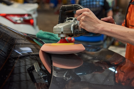 Hands Polishing Car With Rotary Car Polisher. Polishing On Car Paint Surface. Foam Pad In Blur Motion From Vibration Of Polisher Machine. Selected Focusの写真素材