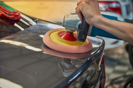 Hands Polishing Car With Rotary Car Polisher. Polishing On Car Paint Surface. Foam Pad In Blur Motion From Vibration Of Polisher Machine. Selected Focusの写真素材