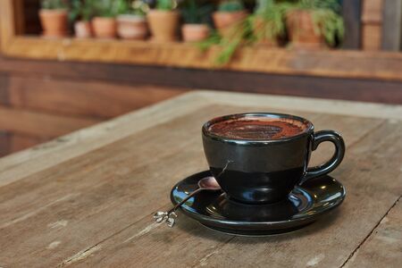 Hot Chocolate In Black Cup On Wooden Tableの写真素材