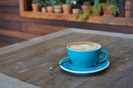 Blue Cup Of Coffee With Latte Art On Wood Tableの写真素材