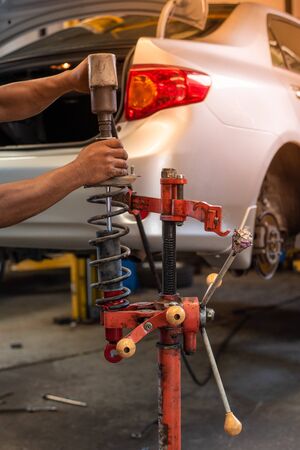 Hands Changing Car Absorber With Red Machine In Auto-Repair Service.の写真素材