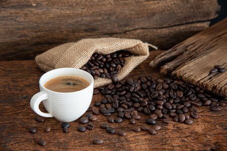 White Cup Of Espresso Coffee And Coffee Beans  On Wood Table.の写真素材