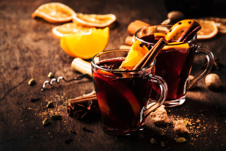 Hot mulled red wine with spices and fruits on wooden rustic table. Traditional Christmas hot drink, copy spaceの写真素材