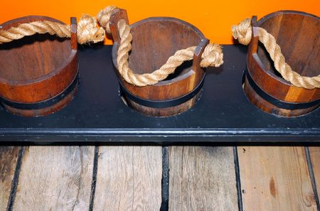 3 wooden buckets in front of orange wallの写真素材