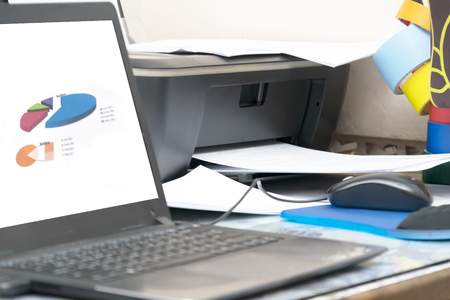 analyzing investment charts, Accounting, Process of the press of paper in the printer, office desk with laptop, computerの写真素材
