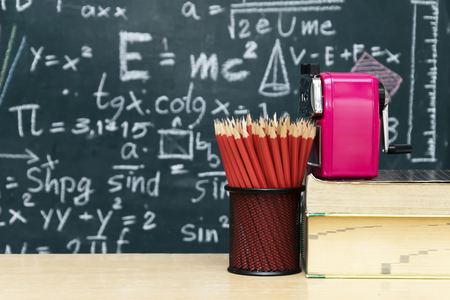 Many red pencils Set in a circular arrangement,eraser,Pencil sharpener Put on the table,The backdrop is Blackboard with mathematical content,Writing with a variety of colors,To stimulate teaching.の写真素材