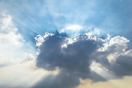 The sky is full of clouds floating around the houses, both small and large, the sun is shining brightly.の写真素材