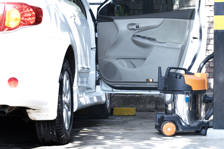 Car Washing. Cleaning Car Using Cleaner cars,Car interior textile seats chemical cleaning with professionally extraction method. Early spring cleaning or regular clean up,White car,vacuum cleaner.の写真素材