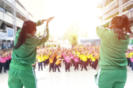 Blurred photo,Step aerobics exercise class - group of people exercising with the 2 trainers,Is teaching a lot of students to exercise,Give a green sweatshirt,Students in multicolored shadesの写真素材