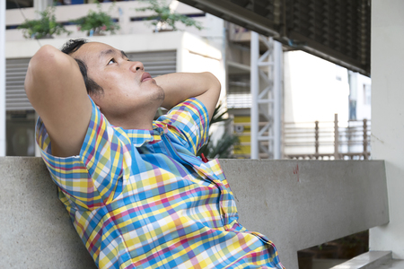 Men are dismayed about his work, not achieving the goals that have been laid,
Sit against the wall and put your hands behind the head,Eyes look up.の写真素材