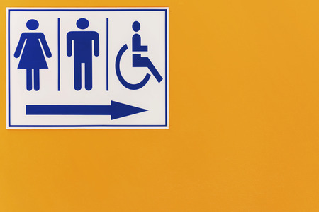 Equality in society is a matter for concern, Symbols represent communication, Describe the content that you want to present, toilet sign on orange wallの写真素材
