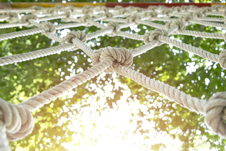 climb net rope close up background and textures,Rope Netting as Healthy Exercise,rope net for adventure game in day light,Acargo net stretched out between trees as part of an adventure climbing course in the forest.の写真素材