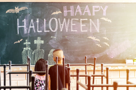 Halloween is celebrated on the night of October 31, We are often referred to as the Pakistani language, Blackboard writing and Two children are standing there watching.の写真素材