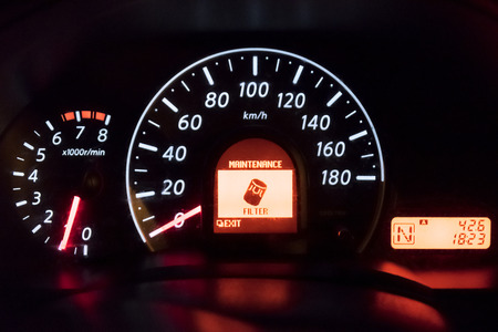 Detail of the dashboard of a car, with the oil alert icon lit up, Oil Change Symbol.