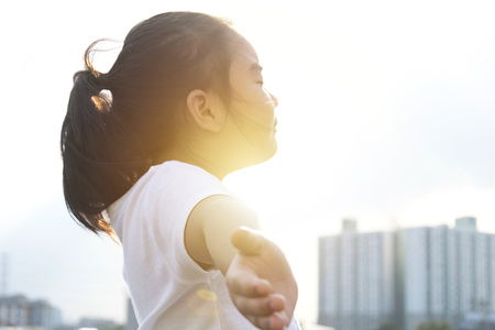beautiful girl doing yoga outdoors On the Top Building, Reflections from the Sun 
Standing arms smoking air fresh, Asian girl with long hair in white shirt.の写真素材