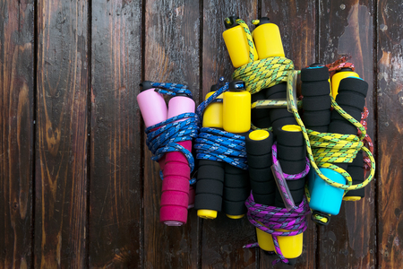 Skipping rope there are many on the wooden floor,The handle is a soft black mitt,Colorful.の写真素材