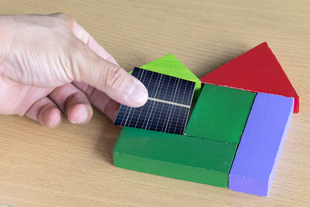 Concept Renewable energy is a necessity of the future world,Energy saving ideas,Hand catch Solar Cell Put on a piece of wood on home.の写真素材