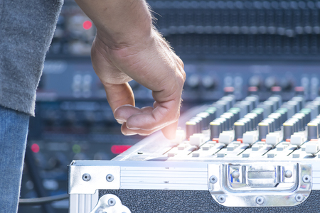 Sound technician and lights technicians control the music show in concert.Professional audio, light mixer controller panel.Pro equipment for concerts.Stage lighting control.Hand adjusting audio mixerの写真素材