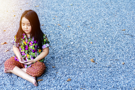 Mental development.lifestyle concept.Meditate yoga hands of Asia girl doing meditation Healthcare.Yoga Awareness.Sitting on the area has many small stones.Hawaiian Clothing.の写真素材