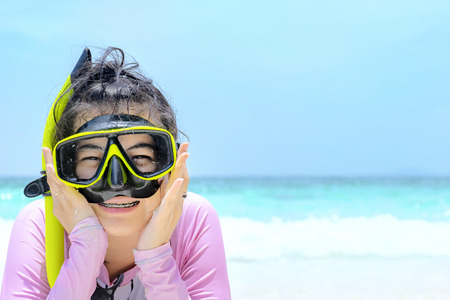 Woman lying on the beach and Swimsuit a pink.Goggles,scuba diving Black-yellow.
Happy smile.The backdrop is sky and sea.の写真素材