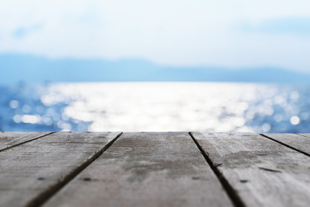 The front is a wooden floor. Blue background.A beautiful bokeh is eye-catching.Natural colors look attractive.Reflections on sea surfaceの写真素材