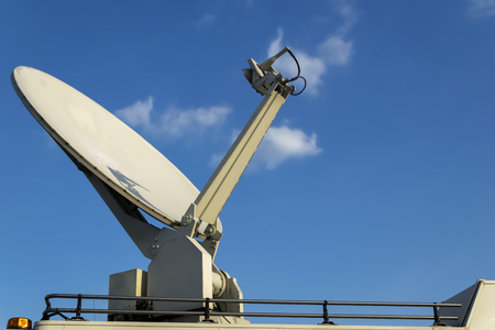 Broadcasting,Parked satellite TV van transmits breaking news events to orbiting satellites for broadcast around the world,Receiving-transmitting satellite dish on the roof of the vehicle journalists.の写真素材