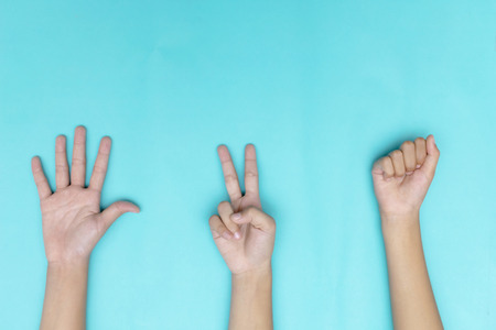 Rock ,Paper ,Scissors - hands isolated on blue background. It's a classic fight. Make a successful settlement among friends.の写真素材
