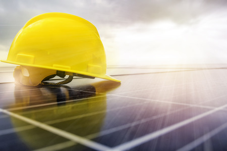 Electric power is very necessary. Make use of your own electricity by using solar panels. Engineer helmet put on photovoltaic.の写真素材