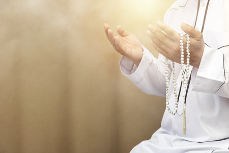 Religious muslim man praying inside the mosque,Men are praying their God Of Islam,Put the pure white dress,Hold Bead necklace hands to the front. Faith in Islamic.の写真素材