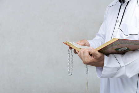 muslim man reading a Quran on gradient background, in Islam study. 
Have faith in religion. Beliefs and truths.の写真素材