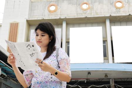Women tourists are looking for a major tourist attraction of the city. The map is a guide to travel.の写真素材