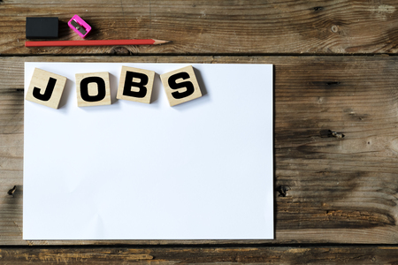 Jobs search concept, Big black text word "JOBS" on wood block. Pencils, erasers, those pencils and notebook to prepare for the job well.の写真素材