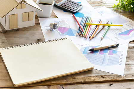 Energy concept, The desk has its place, house models, crayons, bulbs, coffee cup,calculator, Statistical documents, notebooks  for copy Space.の写真素材