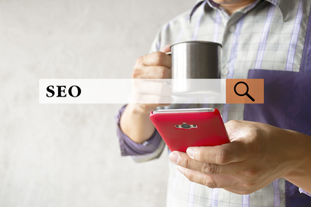 SEO concept. Men who are drinking water with relaxation. Find information on his smartphone. by Search Engine Optimization to get effective information.の写真素材