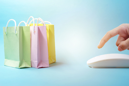Selling Online concept. Order online, is very popular in the present. The fingers are pressing,Just click the mouse and you can get the items you want. Beautiful paper bag model.の写真素材