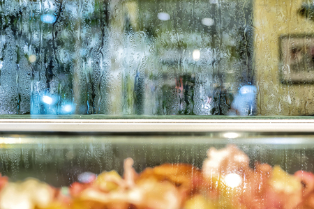 Background the glass of water is at the glass. The granularity is caused by falling rain. Make the media lonely, desolate.の写真素材