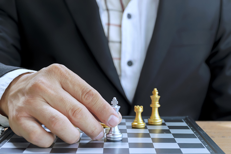 Business battles will require a strong plan. Businessmen who are playing chess by force the player to the other side.の写真素材
