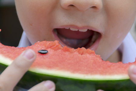 Baby is eating watermelon with delicious. During hot weather, Is open to eat it. watermelon is a good refreshing fruit. Its a bright red color.の写真素材