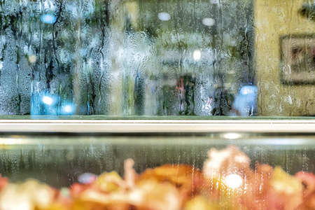 Background the glass of water is at the glass. The granularity is caused by falling rain. Make the media lonely, desolate.の写真素材