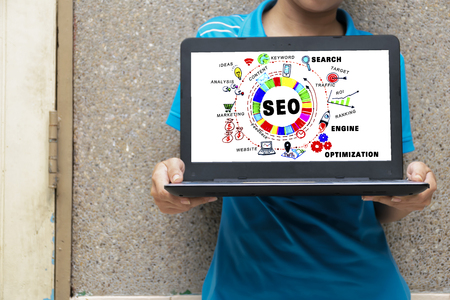 SEO concept. The woman is holding her laptop. Find information by laptop. by Search Engine Optimization Graphic to get effective information.の写真素材